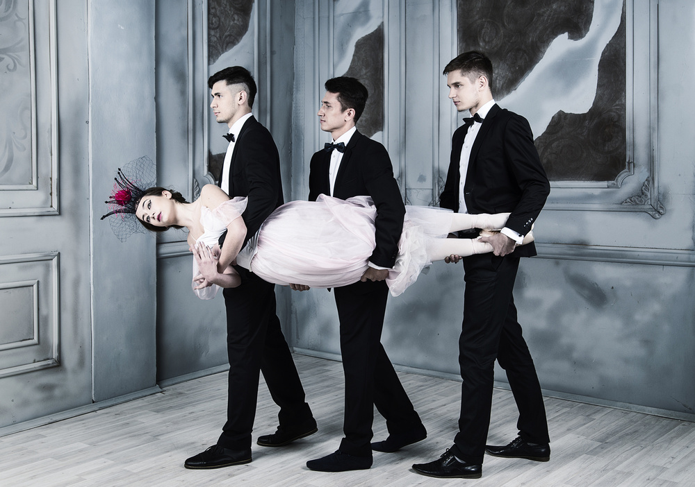Trinity. three men in tuxedos carry a ballerina in their arms from Alexandr