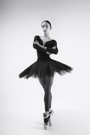 black swan. ballerina in a black tutu shows elements of ballet dance in motion