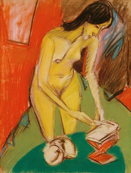 Standing female nude by the table