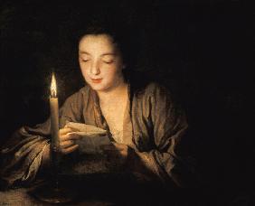 Mädchen, bei Kerzenlicht einen Brief lesend