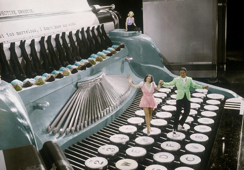 Couple dancing on the key of a giant typewriter, keys are leg of dancers, musical, 30's colourized d from 