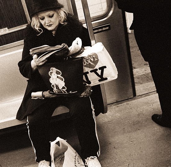 Woman reading on a subway with a Marilyn Monroe purse and an ''I Love New York'' bag, 2004 (b/w phot from Stephen  Spiller